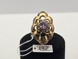 a close up of a gold ring with a purple stone on it