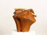 wooden sculpture of a woman ' s head with a wooden handle on a pedestal