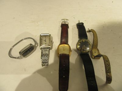 trois montres et un porte-clés posés côte à côte sur une table