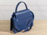 a small blue purse sitting on top of a wooden table