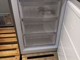 a white refrigerator with its door open on pallets