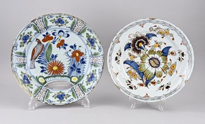 deux assiettes décoratives ornées d'oiseaux et de fleurs, présentées sur un présentoir