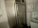 a stainless steel refrigerator next to a sink in a room