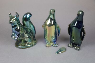 three glass figurines of different shapes and sizes sitting next to each other