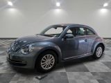 une photo d'une Coccinelle Volkswagen grise garée dans un garage