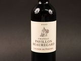 the bottle of red wine is sitting on a black surface