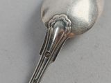 a silver spoon with a spoon shaped like a squid on it