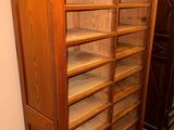 a tall wooden bookcase with many shelves on it