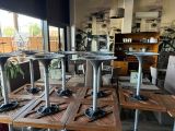 quatre tables et quatre chaises dans une pièce dotée d'une grande fenêtre