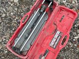 a red tool case with tools in it on the ground