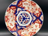 a red and blue plate with a circular design on it