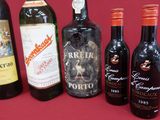 several bottles of wine are lined up on a red surface
