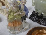 several figurines are displayed on a table with a white table cloth