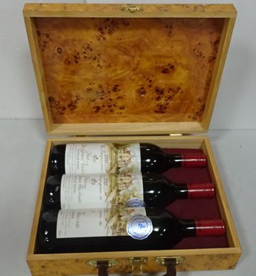 three bottles of wine in a wooden case