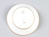 a white plate with gold trim and a flower on it