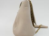 the back of a beige purse with a chain hanging from it ' s side