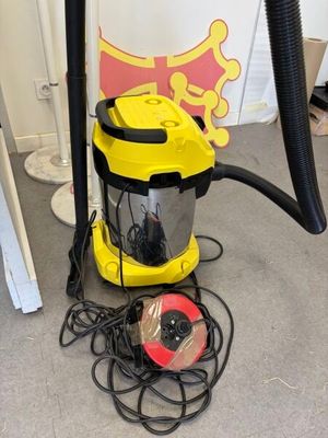 un aspirateur jaune et noir posé par terre à côté d'un objet rouge et jaune