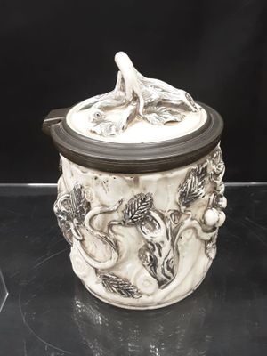 a white jar with a bird on it on a table