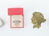 a small box with a ring, a coin, and a broocht