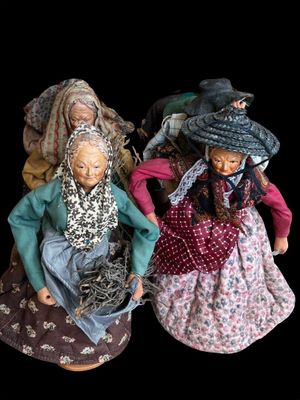 three figurines of women dressed in traditional clothing