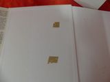 a piece of paper with gold foil on it sitting on top of an open book