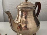 a silver tea pot and a silver teapot on a table