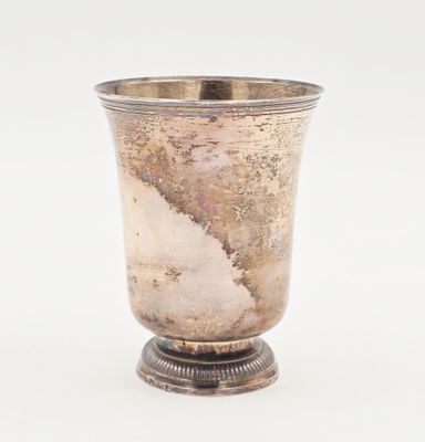 une coupe en argent ancien posée sur un socle, sur fond blanc