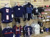 a wall of clothes and bags on display in a store