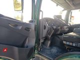a green truck with the door open and the driver ' s seat down