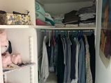 a closet full of clothes and toys in a small room
