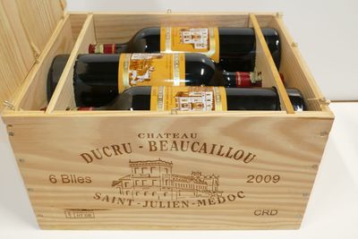bouteilles de vin dans un coffret en bois sur une surface blanche