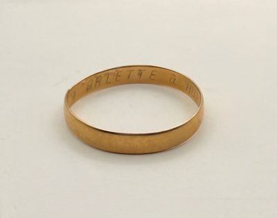 gros plan d'une bague en or sur une surface blanche