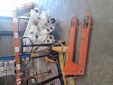 a large stack of pipes on a pallet next to a wall