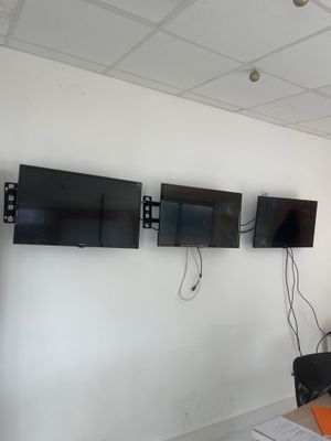 trois téléviseurs fixés au mur dans une pièce