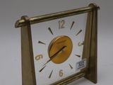 a gold clock sitting on top of a white table