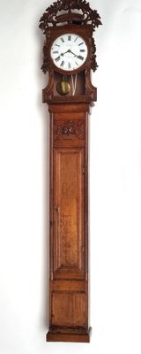 a wooden grandfather clock hanging on the wall next to a white wall