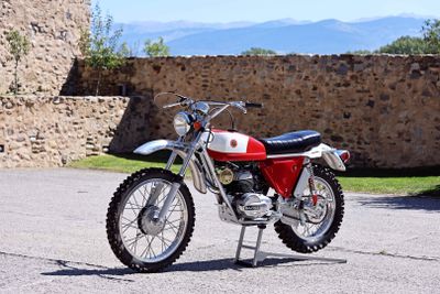 a red and white motorcycle parked in front of a stone wall