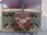 a small metal box with a wooden handle on top of it