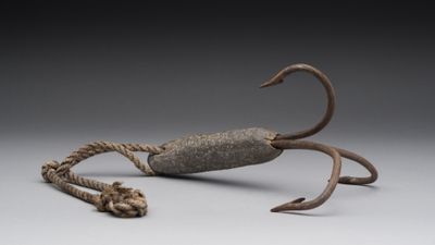 un gros plan sur une sculpture représentant un crabe posée sur une surface grise