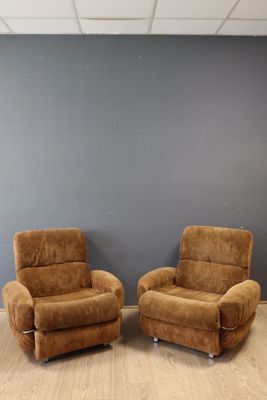 deux chaises marron placées devant un mur gris dans une pièce