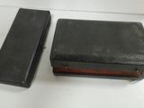 two pieces of black luggage sitting on top of a white table