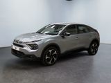 un SUV argenté garé dans une pièce au sol noir