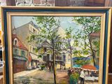 un tableau représentant une scène de rue, posé sur un chevalet