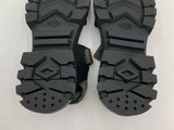 the soles of a pair of black hiking boots on a white surface