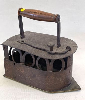 an old iron with a wooden handle on a white surface
