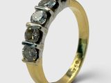 un gros plan sur une bague en or sertie d'une rangée de diamants bleus