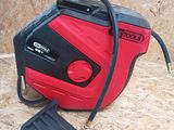 a red and black portable air compressor on a wooden floor