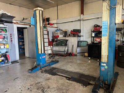 un garage avec deux ponts élévateurs bleus à l'intérieur