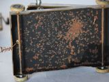 a small black and gold suitcase sitting on a table