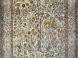 an antique persian rug with a tree of life in the center